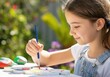 © Running opossum - Young girl painting colorful rocks in a garden setting, enjoying a creative outdoor activity
