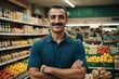 © ThomasLENNE - Close portrait of a smiling 40s Azerbaijani male grocer standing and looking at the camera, Azerbaijani grocery store blurred background
