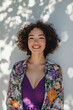 © olegganko - Cheerful woman with curly hair wearing floral shawl enjoying a sunny day outdoors
