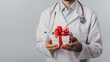 © Elena - Present box in hands of male doctor  , medical promo and congratulations