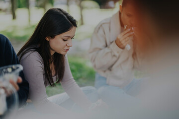 Sticker - A group of students spending a peaceful day outdoors in a park setting, engaged in casual conversation and enjoying snacks. The scene captures a sense of relaxation and camaraderie.