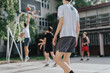 © qunica.com - Group of friends playing basketball at an old court in their neighborhood, showcasing energy, fun, and friendship in an outdoor sports environment.