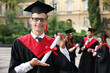 © New Africa - Happy students with diplomas after graduation ceremony outdoors, selective focus