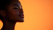© julio - Profile of a woman against a warm orange background.