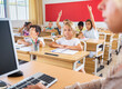 © JackF - Group of focused pupils sitting at classroom working at class with teacher, looking at board