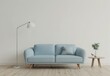 © PERFECTisME - A light blue tufted sofa with a floor lamp and side table in a minimalist living room with wood floors and a white wall