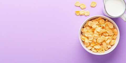 Canvas Print - Bowl of corn flakes and jug of milk on a purple background, top view.