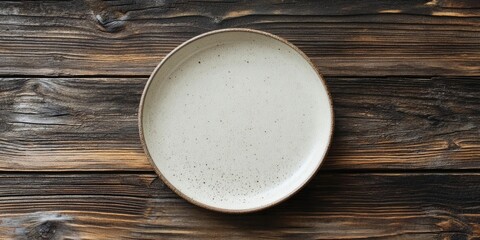 Poster - Empty ceramic plate on a wooden surface. Top view with copyspace.