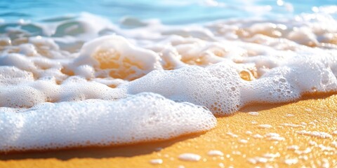 Poster - Close-up summer scene featuring blue sea water, white foam, and yellow sand with selective focus. Represents vacation or holiday theme. Nature backdrop with copyspace.