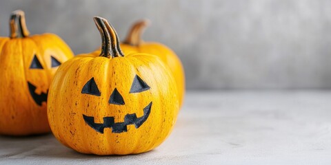 Poster - Close-up of yellow festive decorated pumpkins on a light background. Halloween theme.