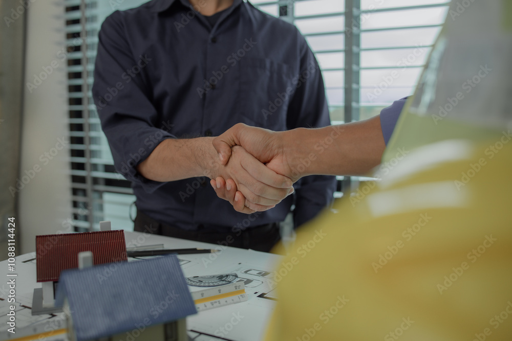 engineer and architect are shaking hands to celebrate because they just ...