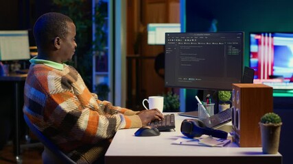 african american self employed developer in home office coding on his computer at workstation. focus