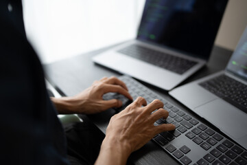 Asian man software engineer Working on Computer at office desk for writing program code IT Software Engineer finding errors tech support devops creating digital