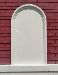 Wall Mural - A brick wall with a white archway in the middle