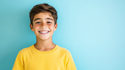 Cheerful young boy with a bright smile against a blue background