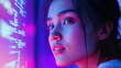 © Happy Photo Stock - A close-up of a young woman illuminated by colorful lights, gazing thoughtfully at a digital display in a futuristic setting.