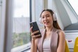 © StockPhotoRepublic - Asian Woman Using Phone and Headphones Listening To Music and Playing Games While Commuting To Work in a Public Train
