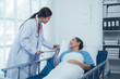 © Kritdanai - Compassionate Care: Doctor and Patient. A reassuring moment between a female doctor and her elderly patient in a hospital room.  The image conveys empathy, trust, and healing.