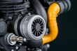 © Pixelbiz - Turbocharger installation concept. A close-up view of a turbocharger with a vibrant orange hose, showcasing intricate details of automotive engineering.