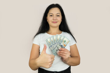 Wall Mural - A woman holds dollars in her hands. Portrait of a woman with dollars.