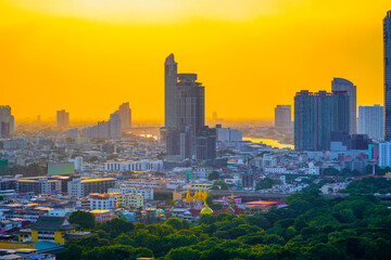 Wall Mural - Sunset over modern office buildings in business district. Skyline view of cityscape with disc sun sunlight and flare.