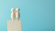 © fajar - Two wooden figures standing on top of a stack of wooden blocks. The blocks are stacked on top of each other