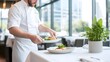 © Warakorn - A chef preparing food for a group seated in an open kitchen restaurant