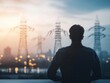 © Khuefa - A person observing power lines at sunset, symbolizing the intersection of nature and technology in modern life. Energy stock investment concept.