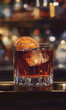 © adince - A Whiskey Tumbler Filled with Dark Bourbon and Orange Garnish for a Bold Drink