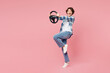 © ViDi Studio - Full body side view young excited surprised shocked woman wear blue shirt white t-shirt casual clothes hold steering wheel driving car isolated on plain pastel light pink background Lifestyle concept