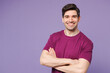 © ViDi Studio - Side view young cheerful Caucasian man he wear violet t-shirt casual clothes hold hands crossed folded look camera isolated on plain pastel light purple background studio portrait. Lifestyle concept.