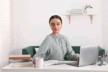 Wall Mural - Student studying with laptop at table indoors