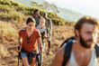 © Marko Geber - Group of friends hiking on a mountain trail at sunset