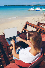 Wall Mural - skilled female millennial freelancer keyboarding on laptop computer with mock up screen working remo