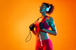 © oneinchpunch - Sportive black hispanic woman wearing sportswear training in fitness studio, colorful dramatic lighting - African-american female athlete doing sport workout