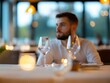 © Priya - a man sitting at a table in a restaurant with a glass of wine and soft lighting