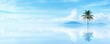 © Navaporn - A tranquil scene featuring a solitary palm tree against a serene blue sky and calm waters, reflecting the beauty of nature.