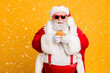 © deagreez - Portrait of funny funky fat santa claus dont care about health eat fast food big sandwich on x-mas tradition celebration wear style stylish suspenders isolated over shine color background