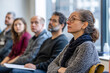 © Vilius - A minimalist stock photo showcasing a diverse group of adults attentively participating in a workshop or seminar. The image emphasizes diversity, education, and collaboration
