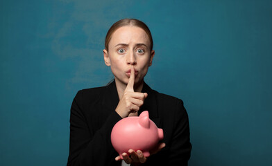 Wall Mural - young blonde woman with a piggy bank