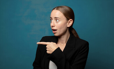 Wall Mural - feeling shocked and surprised, pointing and looking upwards in awe with amazed, open-mouthed look