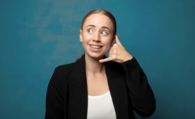 Wall Mural - smiling cheerfully and pointing to camera while making a call you later gesture, talking on phone