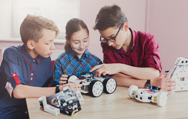 Children creating robots at school, stem education, copy space. Early development, diy, innovation, modern technology concept