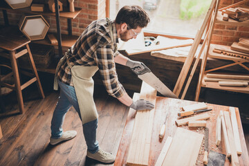 Wall Mural - Top photo of guy artisan cut wood plank with saw tool on table in garage indoors