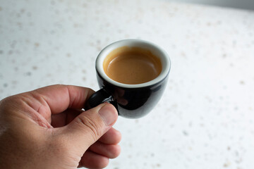 Wall Mural - A view of a hand holding an espresso shot.