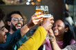 © Xavier Lorenzo - Young group of multiracial people toasting cold beer at happy hours brewery bar. Happy hour and after work concept