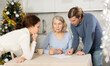 © JackF - Adult married couple helps elderly woman make will testament, declaration for loan, application for settlement in nursing home during winter holiday