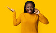 © Prostock-studio - Unexpected Call. Portrait Of Surprised Young Black Woman Talking On Cellphone And Emotionally Gesturing, African Lady Having Phone Conversation, Standing Over Yellow Background In Studio, Copy Space