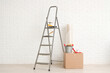 © Pixel-Shot - Stepladder with painter's supplies near white brick wall in room
