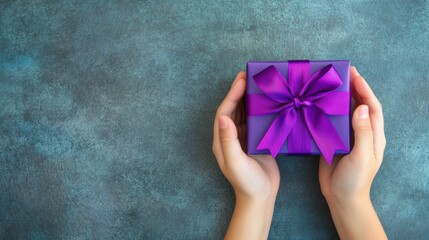 Wall Mural - Hands are carefully cradling a neatly wrapped gift box featuring a striking purple ribbon on a simple, textured surface